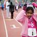 A Girls on the Run participant places a medal around her neck after the race on Sunday. Executive Director Danielle Plunkett says every girl who crosses the finish line is a winner. Daniel Brenner I AnnArbor.com
